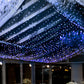 Blue 600 LED twinkle fairy lights in a curtain string display.