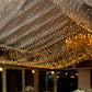 Warm white LED curtain string lights illuminating a festive venue.