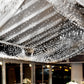 Cool white LED curtain string lights illuminating a festive indoor space.