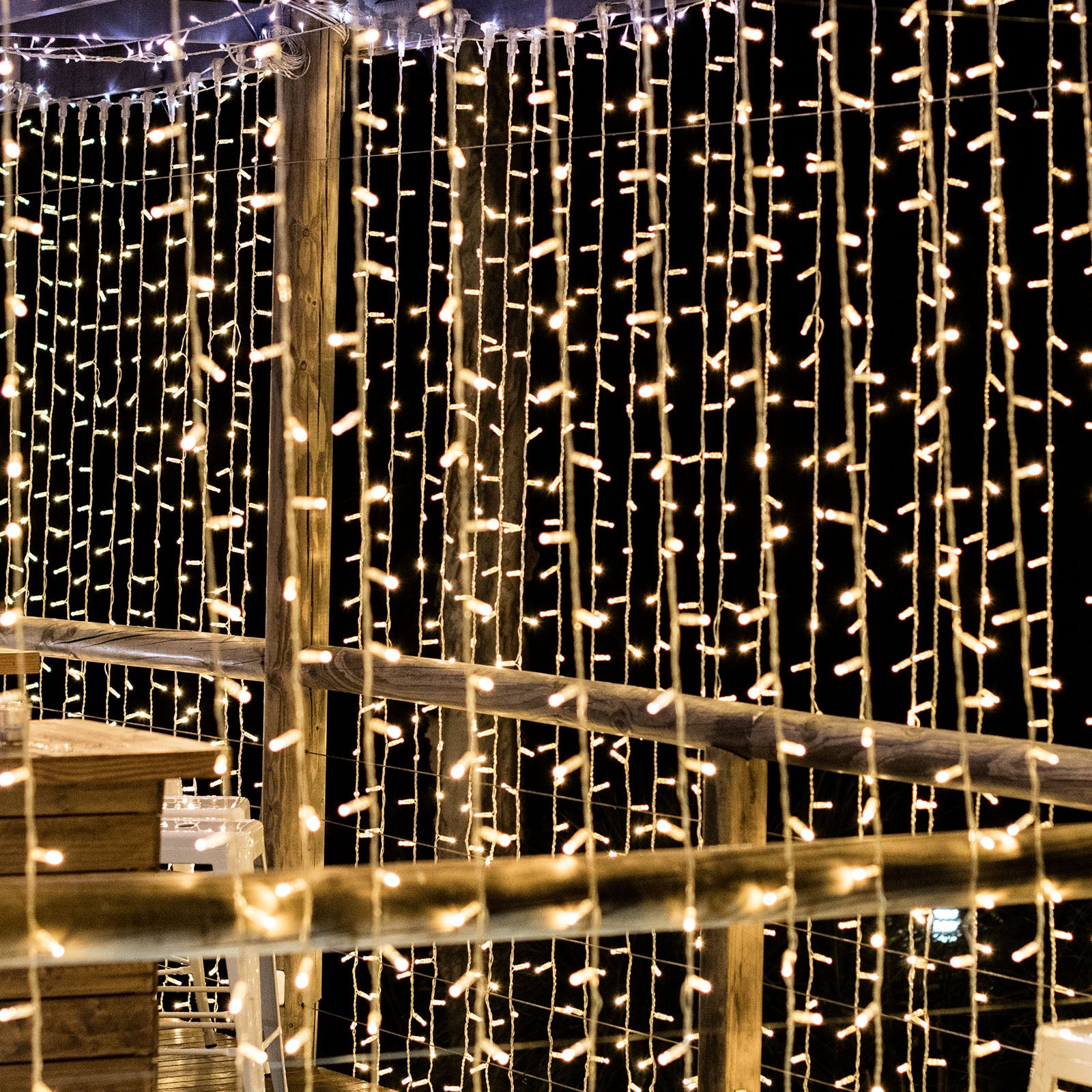 Warm white LED curtain fairy lights hanging outdoors.