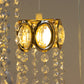 Gold oval frame with teardrop pendants in warm white light.