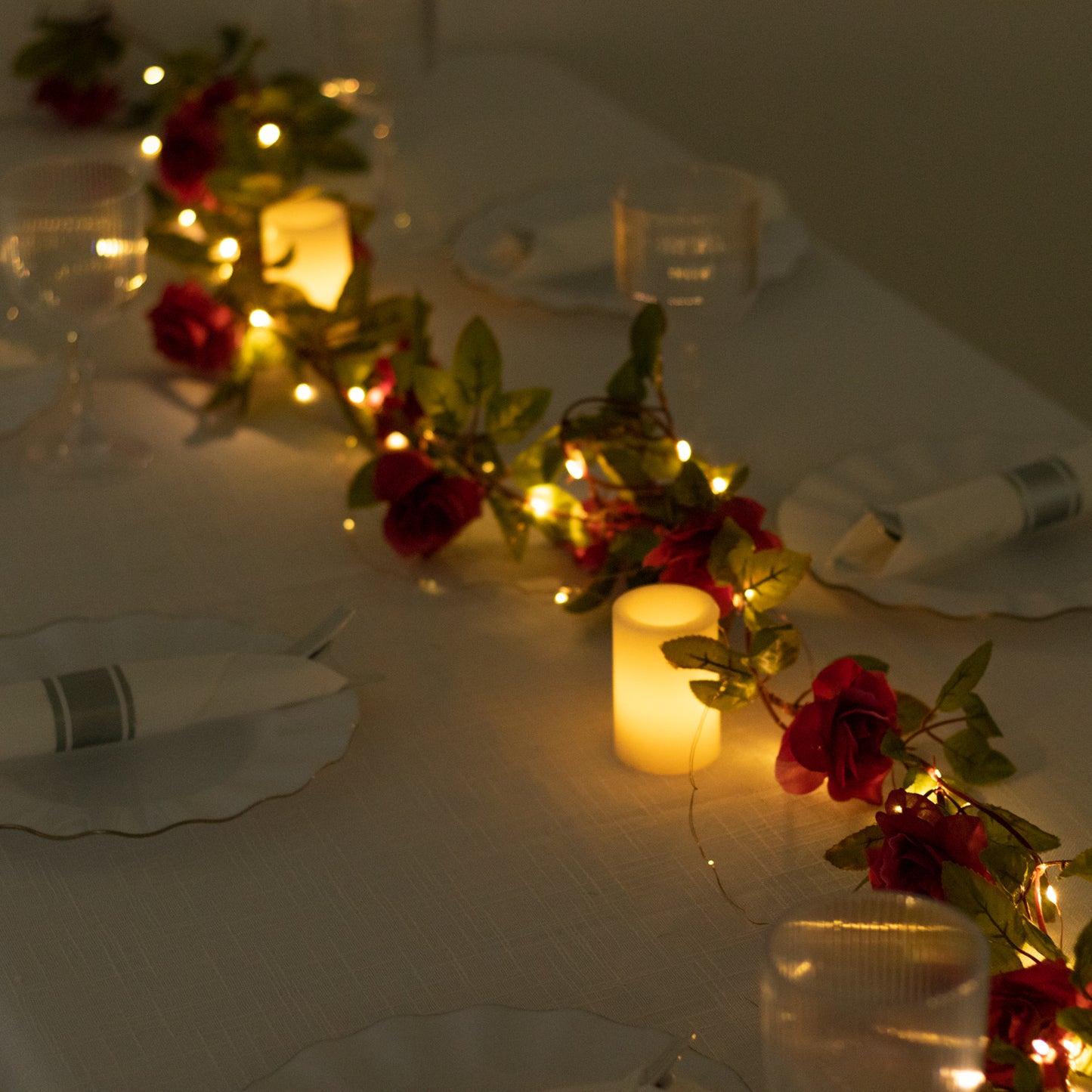 Red silk rose flower garland with warm white LED lights.