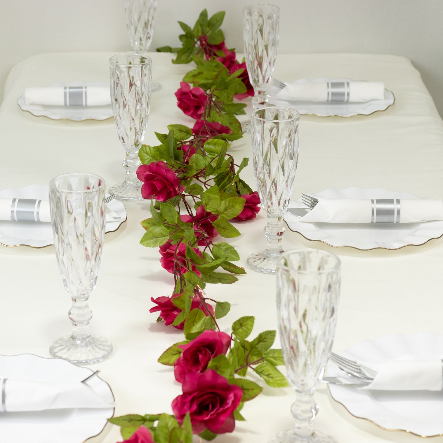 Red silk rose flower garland string lights on a table setting.
