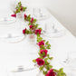 Red silk rose flower garland vine string lights on a table setting.