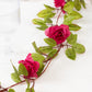 Red silk rose flower garland vine string lights with green leaves.