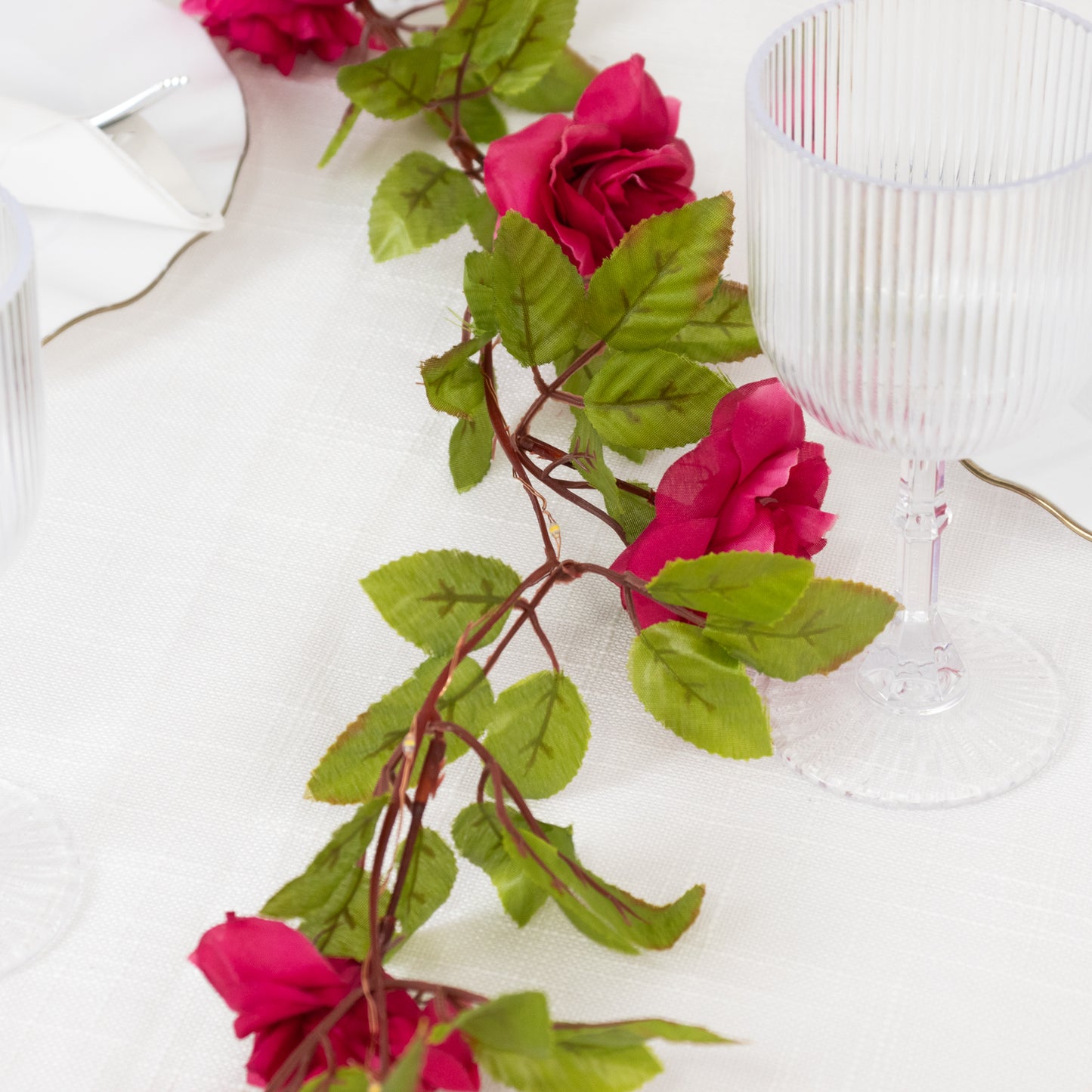 Red silk rose flower garland with warm white lights.