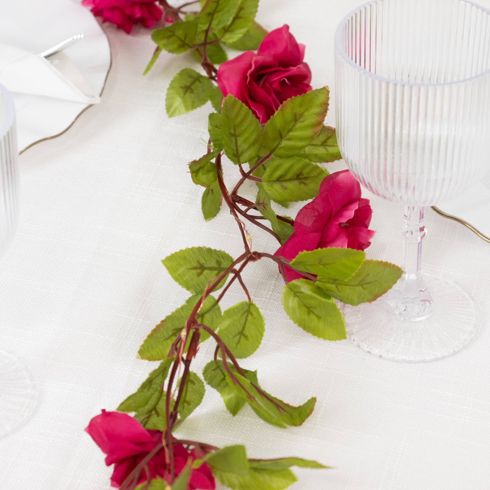 Red silk rose flower garland with warm white lights.