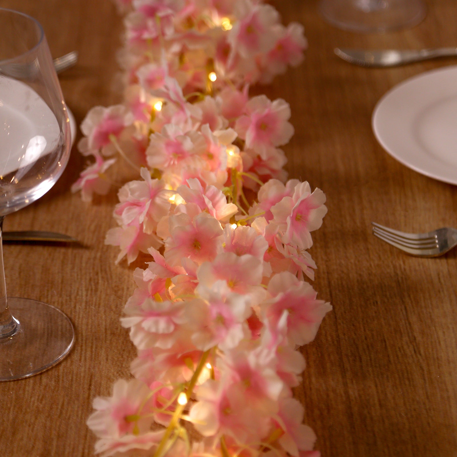 Blush artificial cherry blossom garland string lights with warm white LEDs.