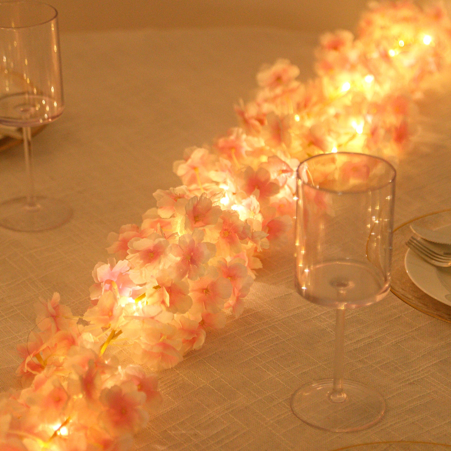 Blush LED cherry blossom garland string lights on a table.