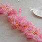 Pink cherry blossom fairy lights with warm white LED glow.