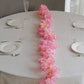 Pink cherry blossom fairy string lights with warm white LEDs on a table.