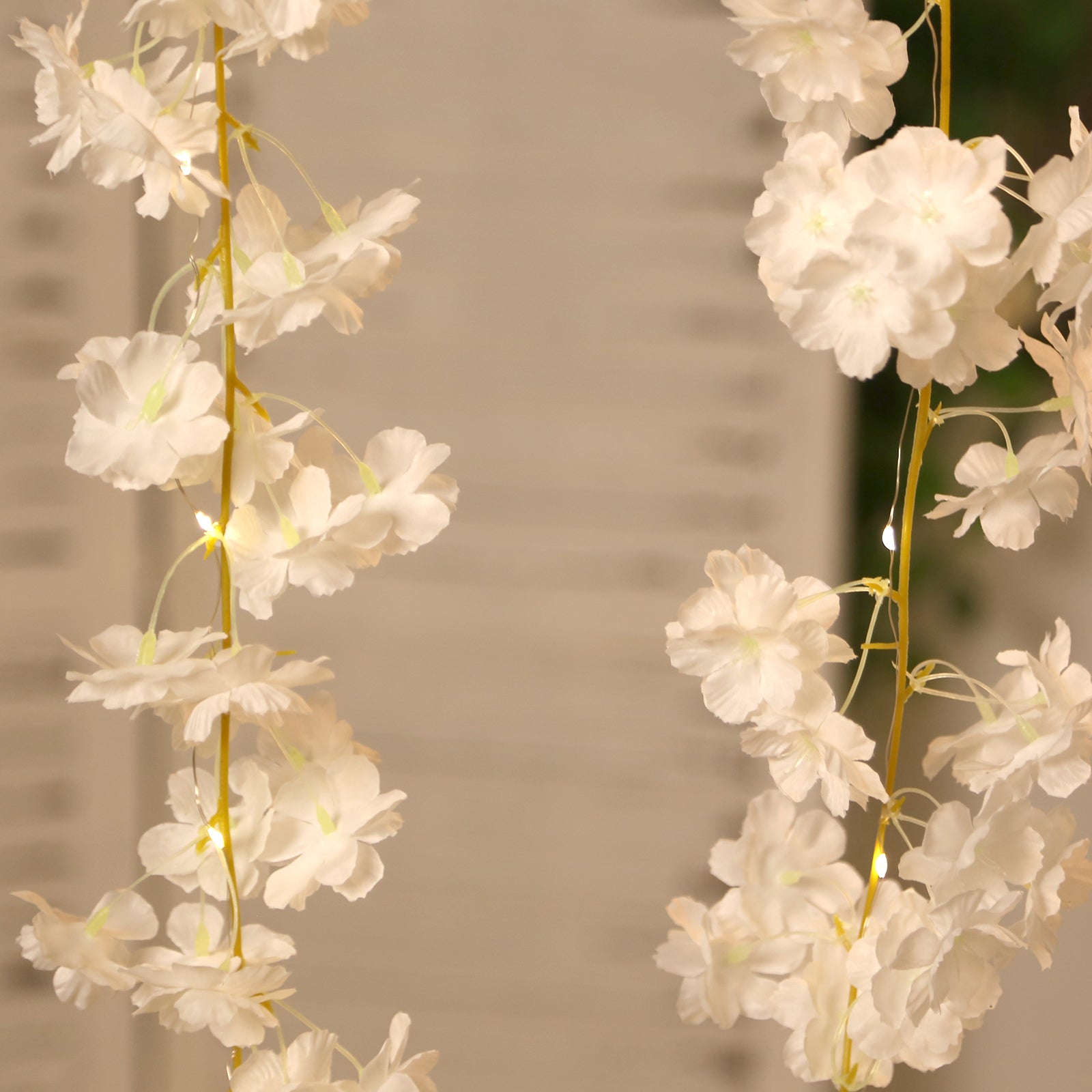 White artificial cherry blossom garland LED string lights with warm white glow.