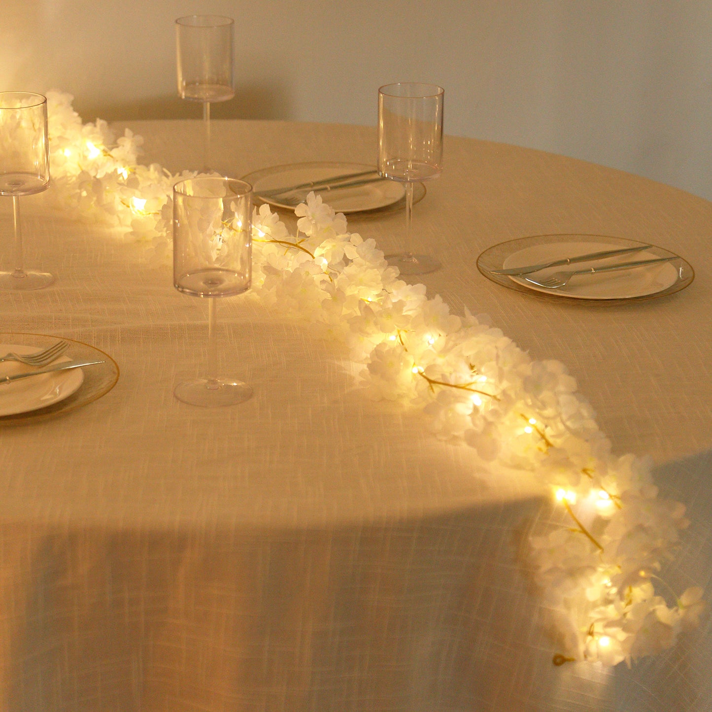 Warm white cherry blossom garland LED string lights on a table.