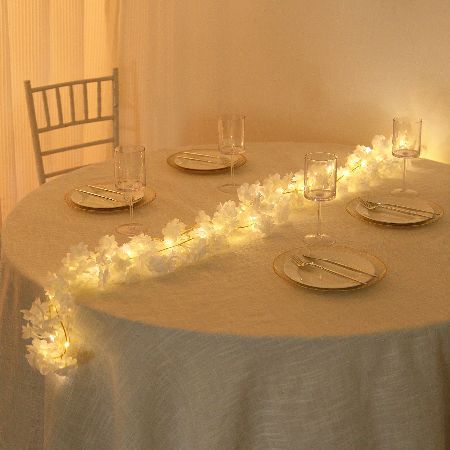 Warm white cherry blossom garland LED string lights on a table setting.