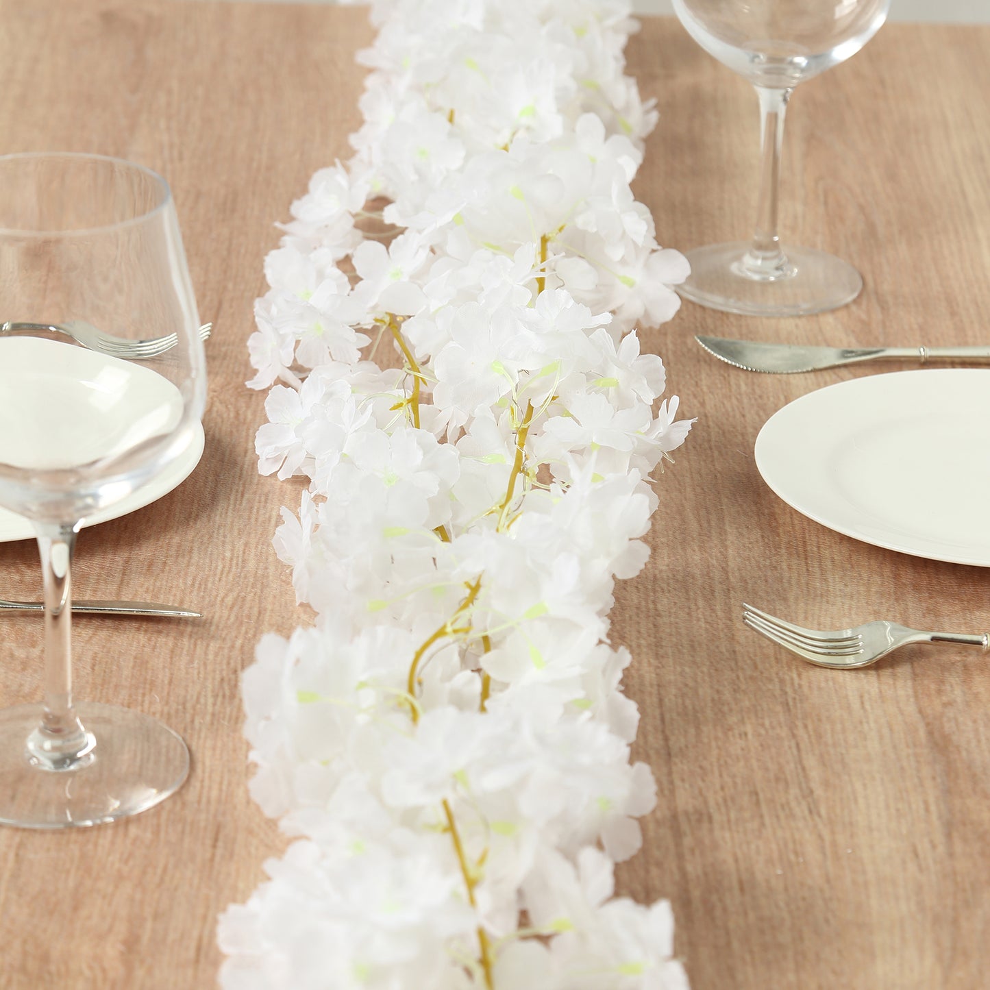 Warm white cherry blossom garland LED string lights on a table setting.