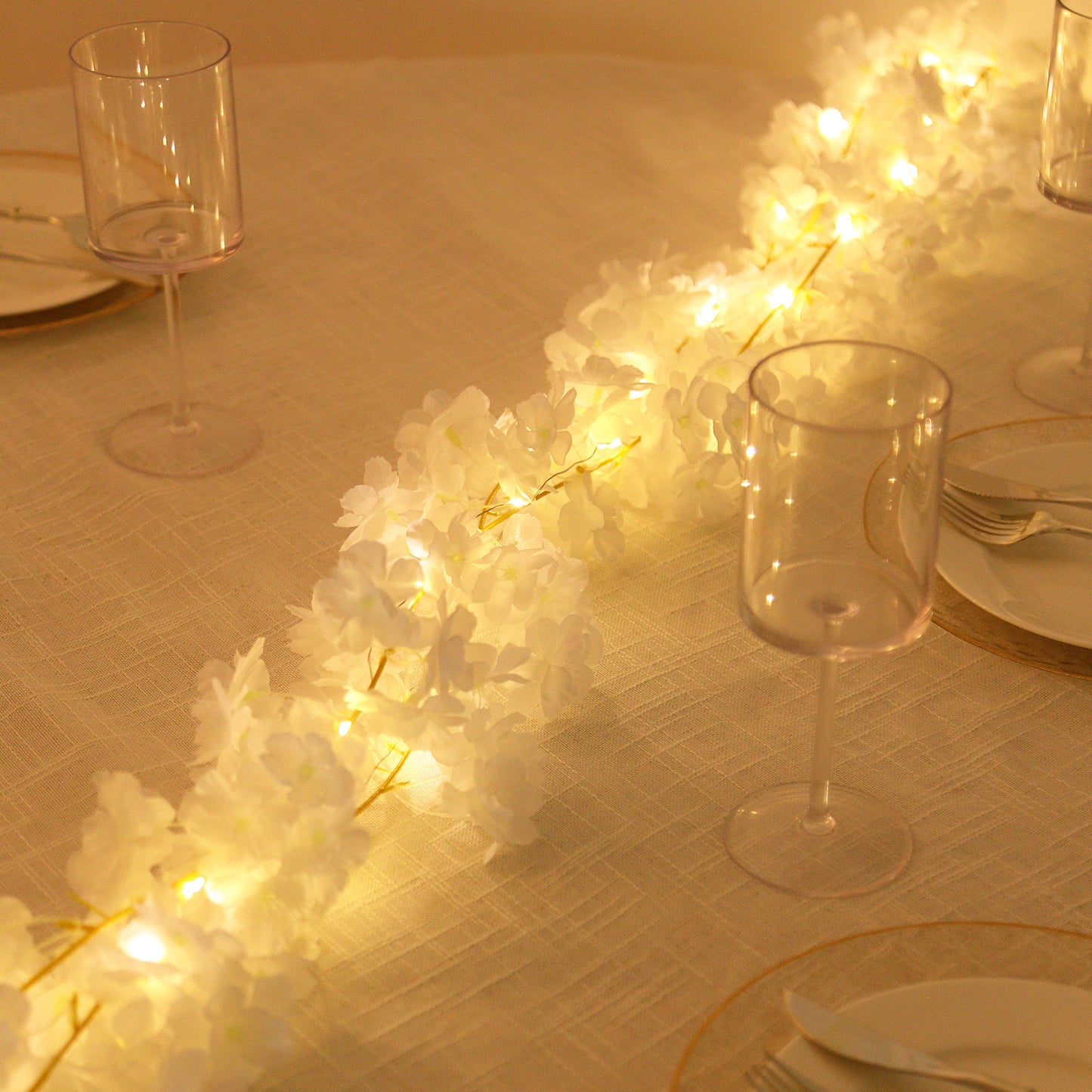 Warm white cherry blossom garland LED string lights on a table setting.