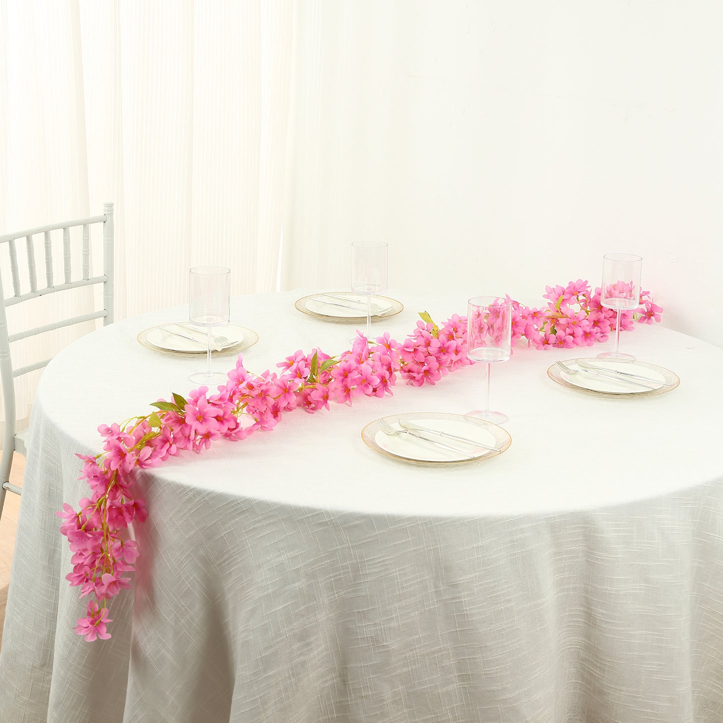 Pink jasmine flower garland with warm white LED lights on a table setting.