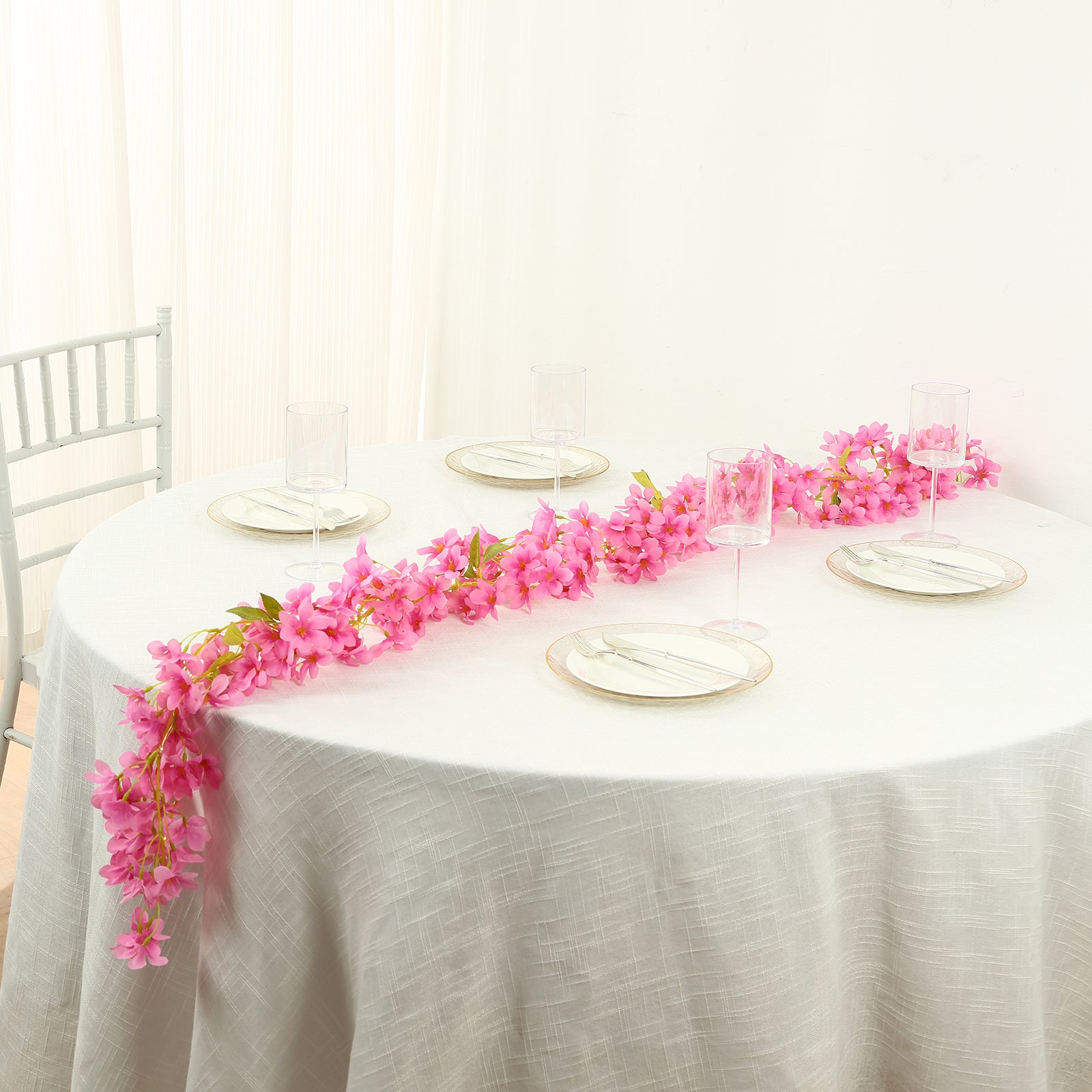 Pink jasmine flower garland with warm white LED lights on a table setting.
