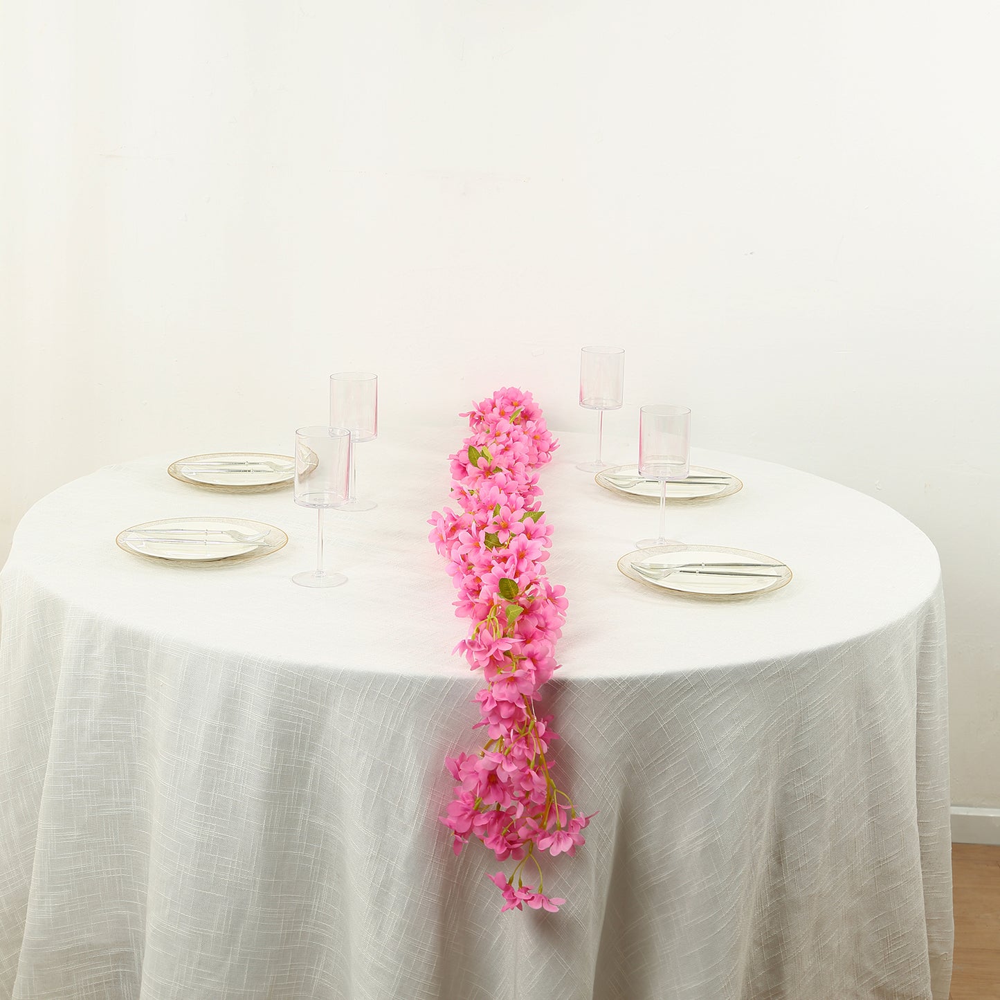 Pink jasmine silk flower garland with warm white LED lights on a table.