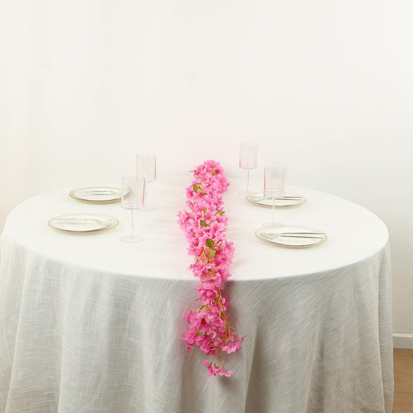 Pink jasmine silk flower garland with warm white LED lights on a table.