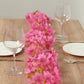Pink jasmine silk flower garland with warm white LED lights on a wooden table.