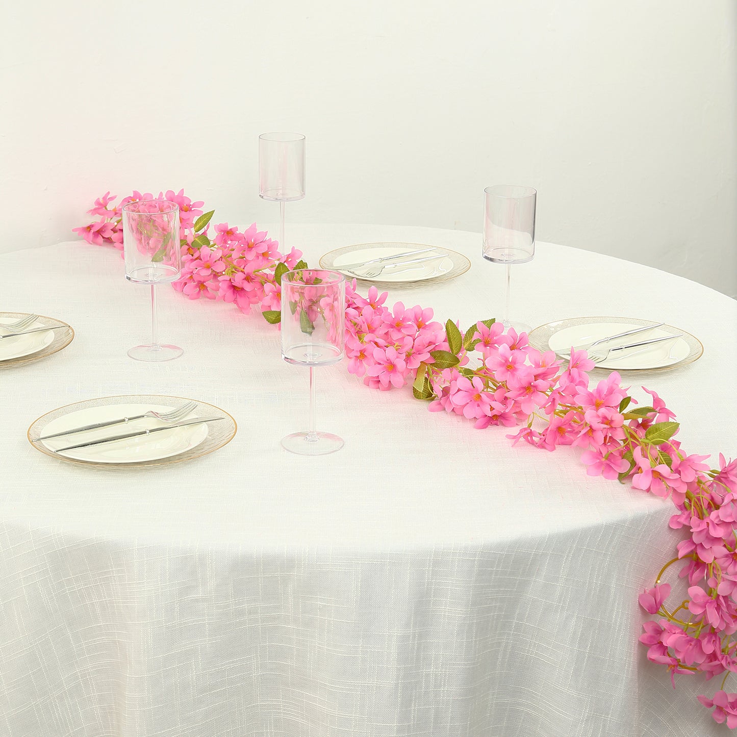 Pink jasmine flower garland with warm white LED lights on a table setting.