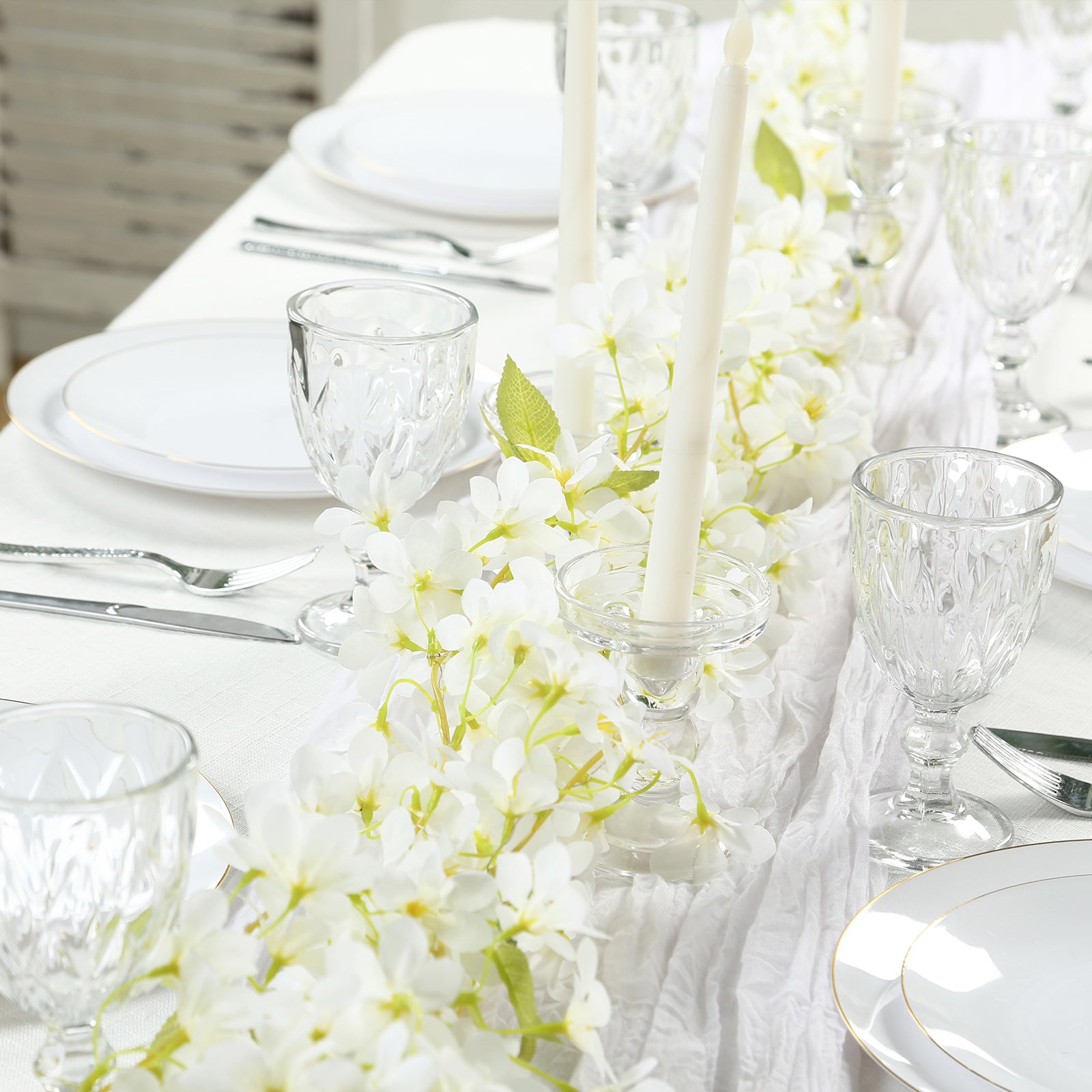 White jasmine silk flower garland with warm white LED lights on a table setting.