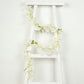 White jasmine flower garland with warm white LED lights on a ladder.