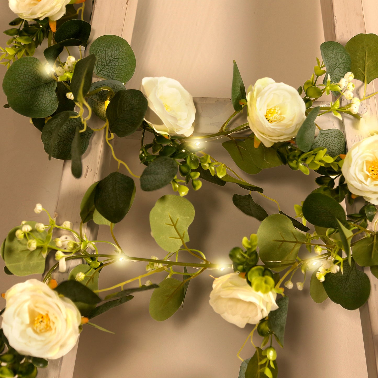 Lighted greenery garland with eucalyptus and peonies, featuring soft white blooms.