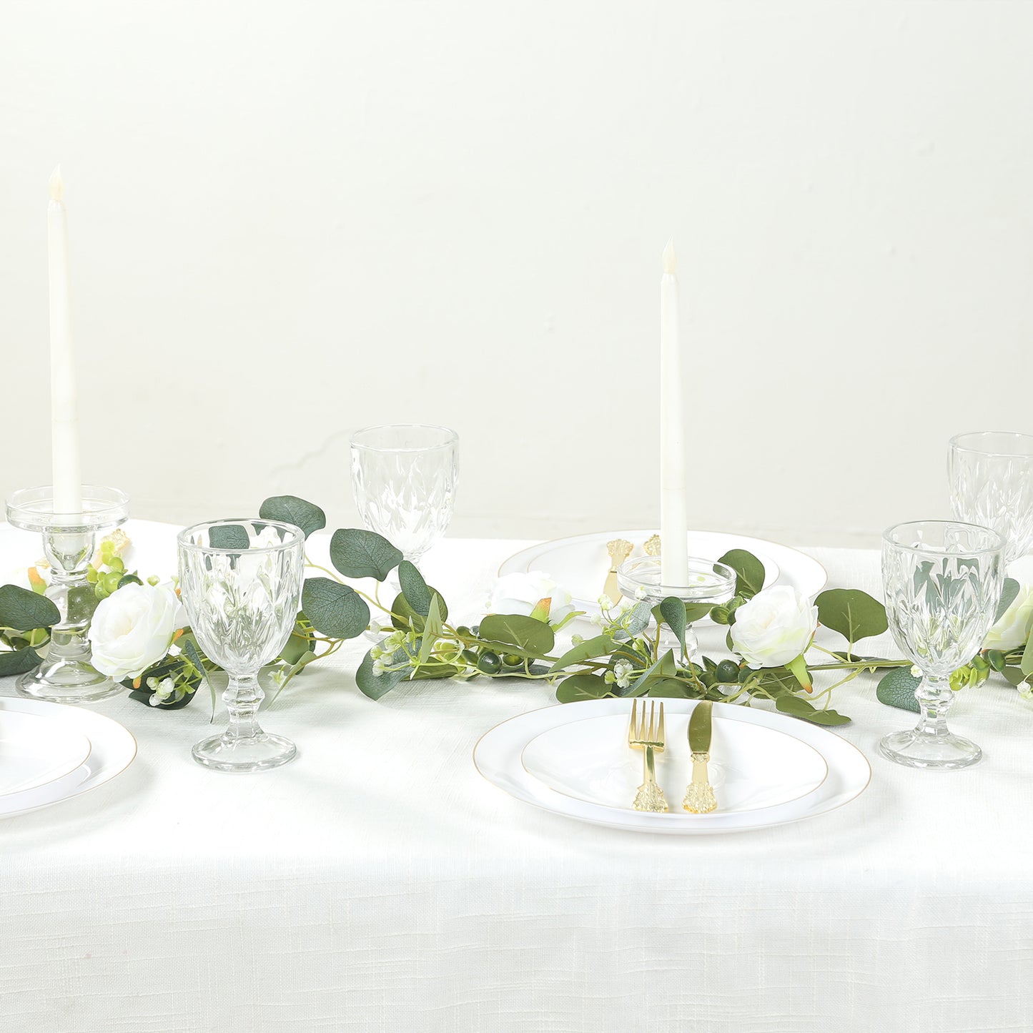 Lighted greenery garland with eucalyptus and peonies on a dining table.