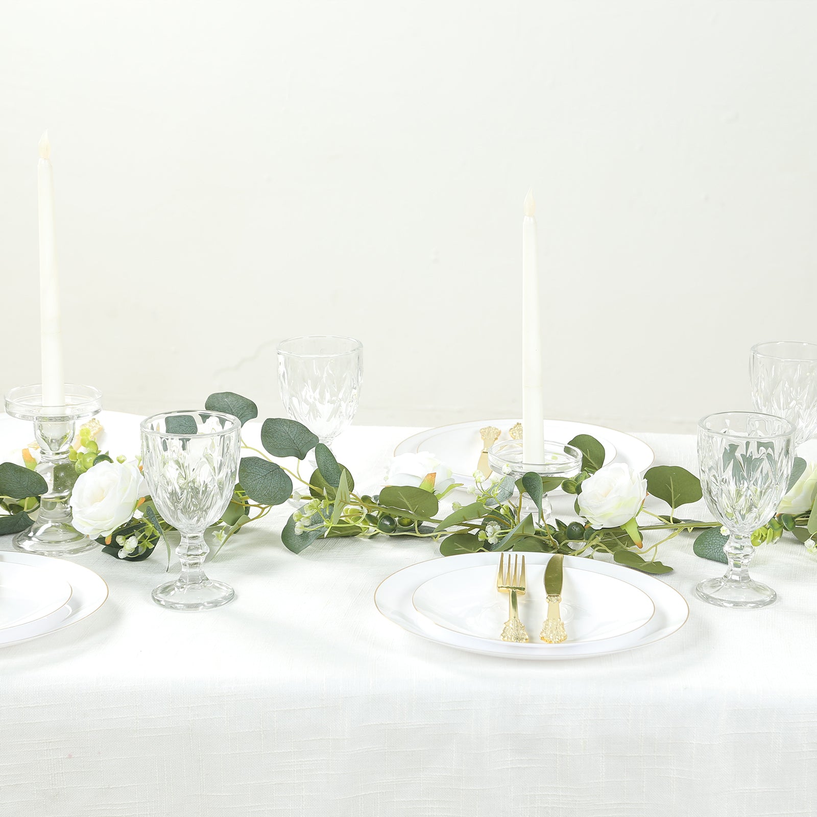 Lighted greenery garland with eucalyptus and peonies on a dining table.