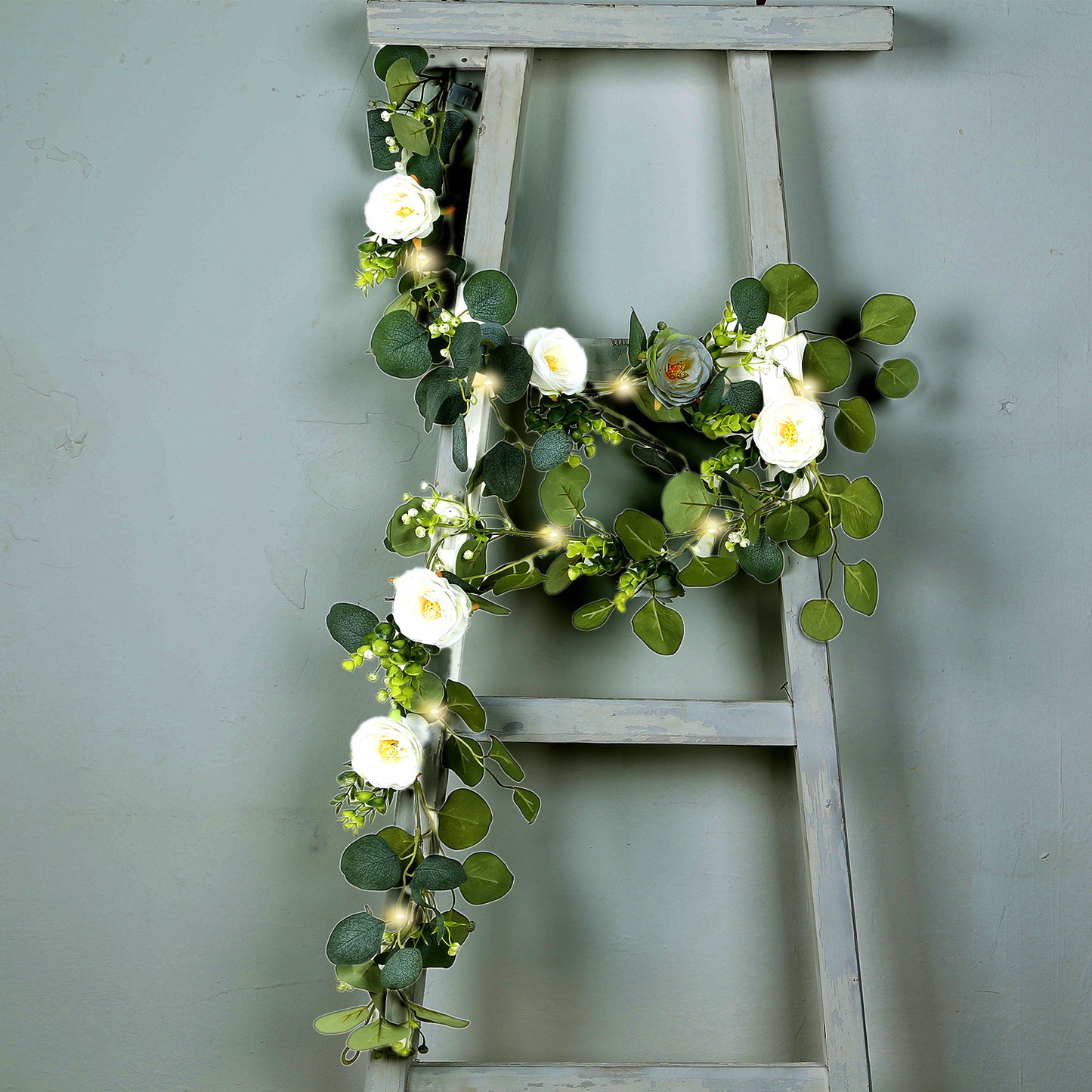 Lighted greenery garland with eucalyptus and peonies in vibrant green.