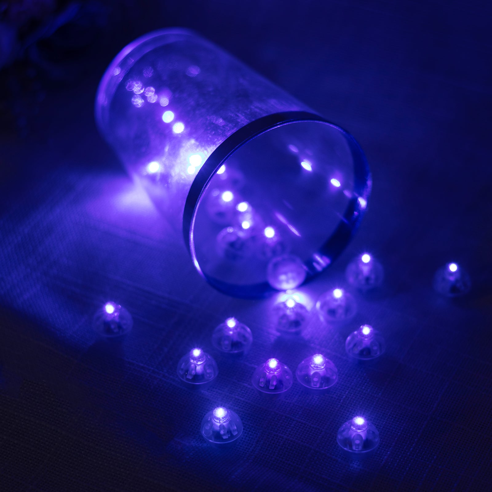 Purple mini LED lights scattered around a clear container.