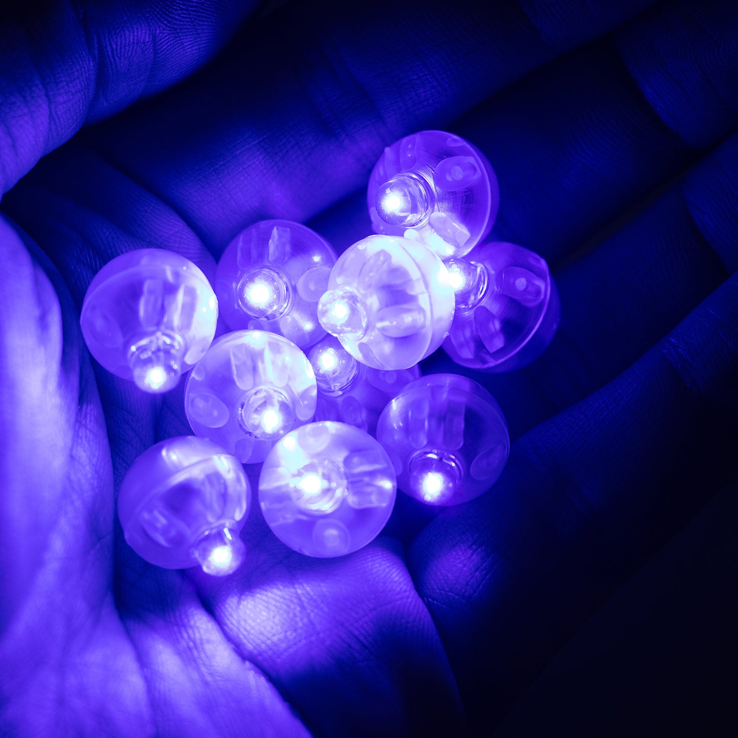Light blue mini LED balls in hand, waterproof and battery operated.