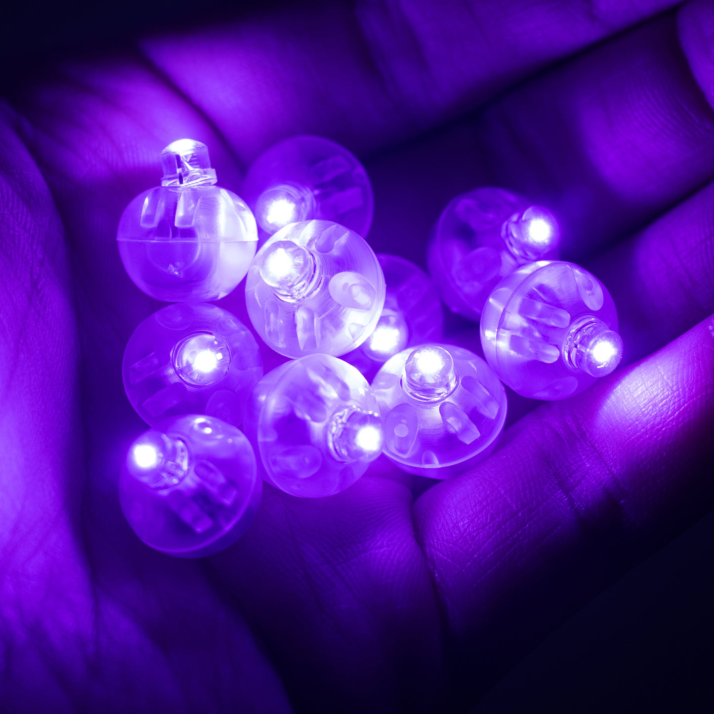 Purple mini LED balls in a hand, battery-operated and waterproof.