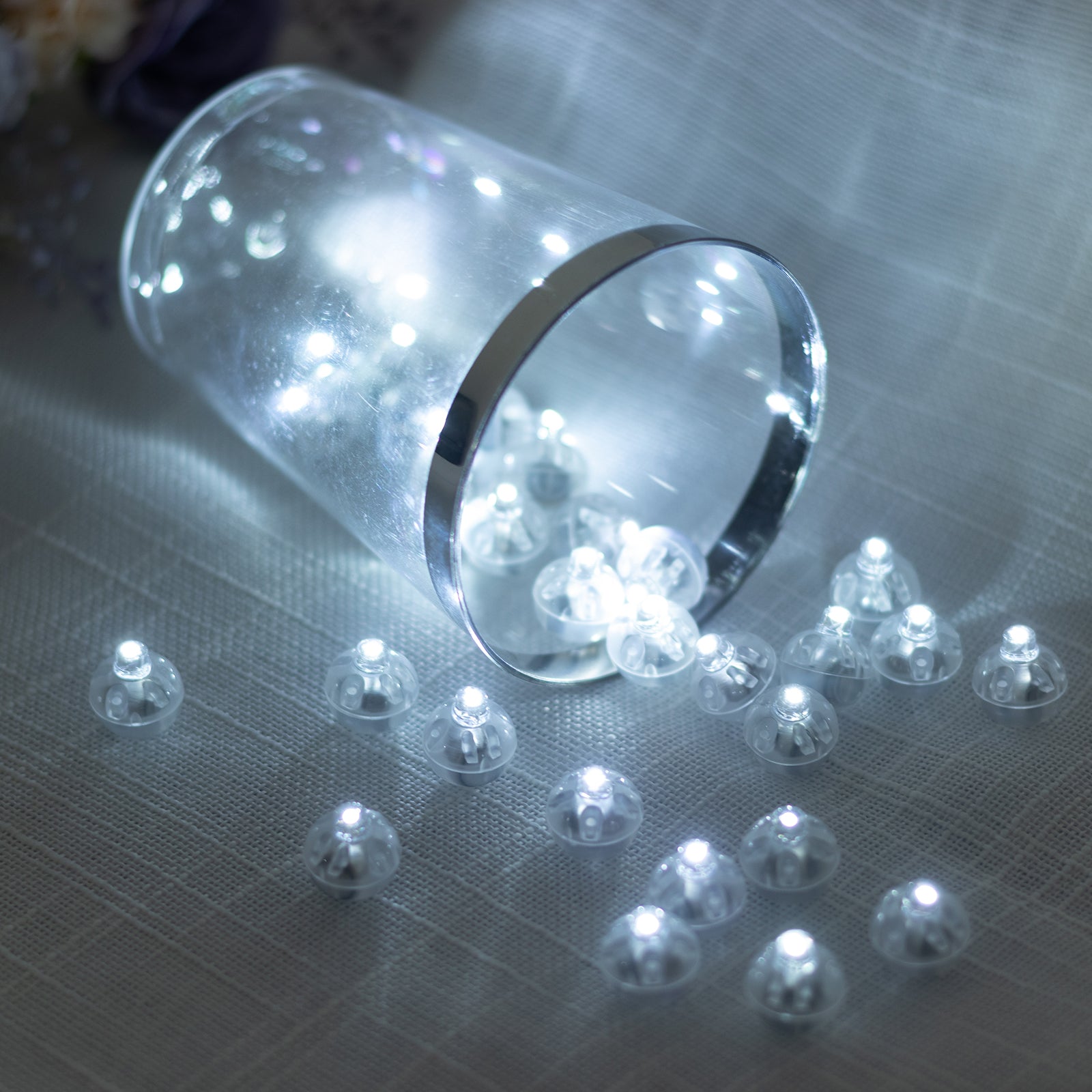 White round mini LED balls, waterproof and battery-operated, scattered on a surface.