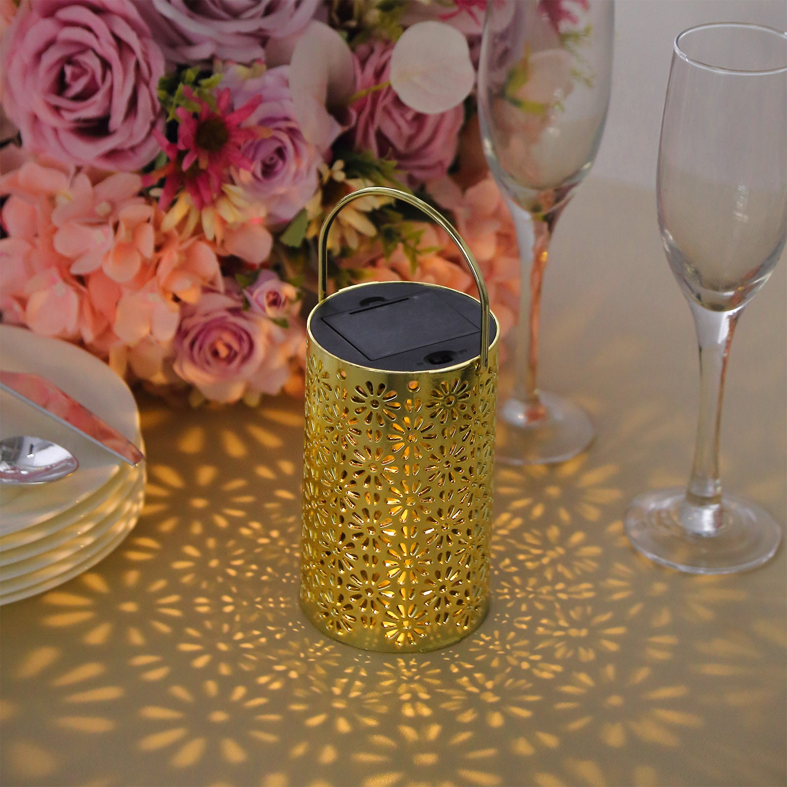 Gold decorative lantern casting floral shadows. Battery operated for garden use.