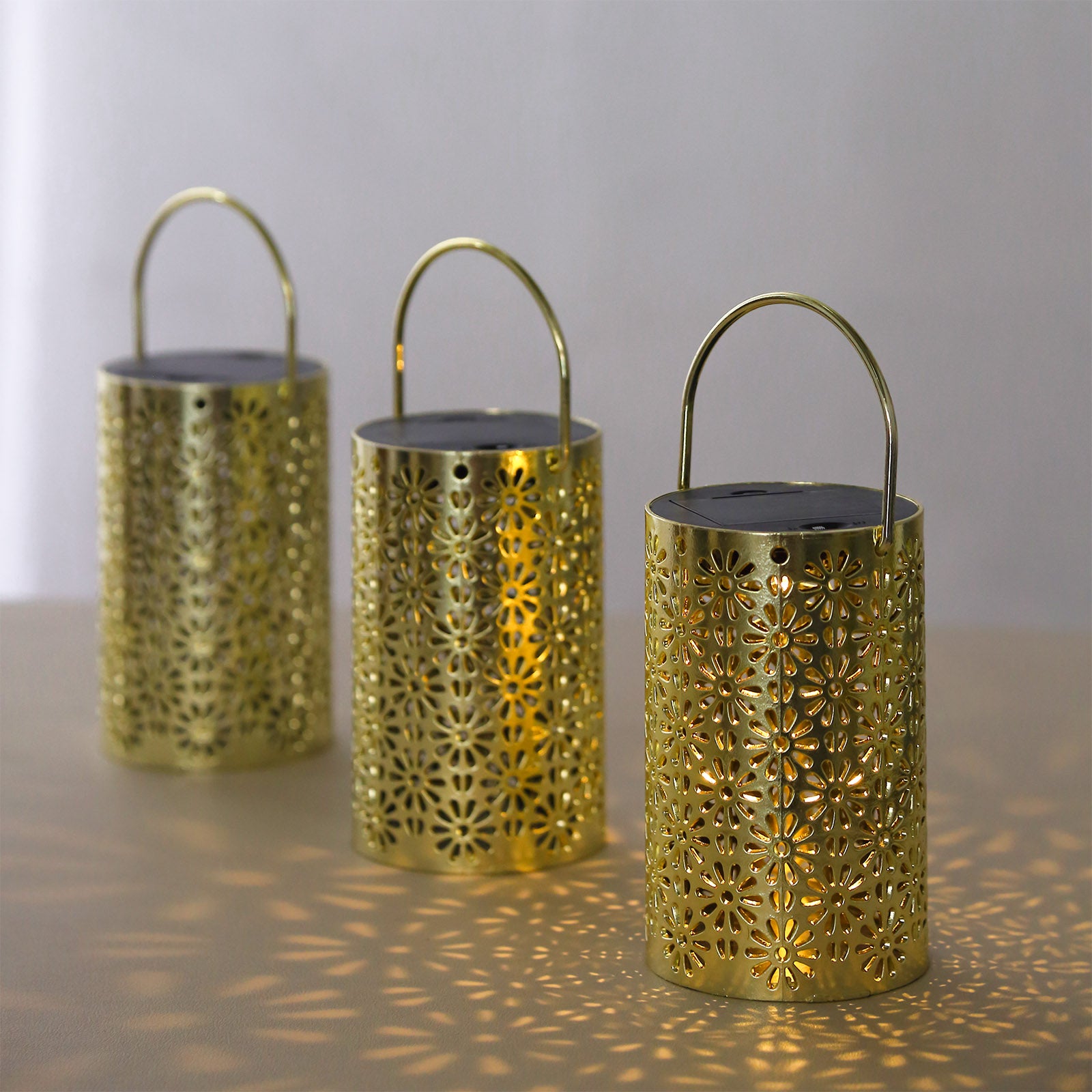 Gold decorative lanterns with flower design, battery operated, perfect for hanging in gardens.