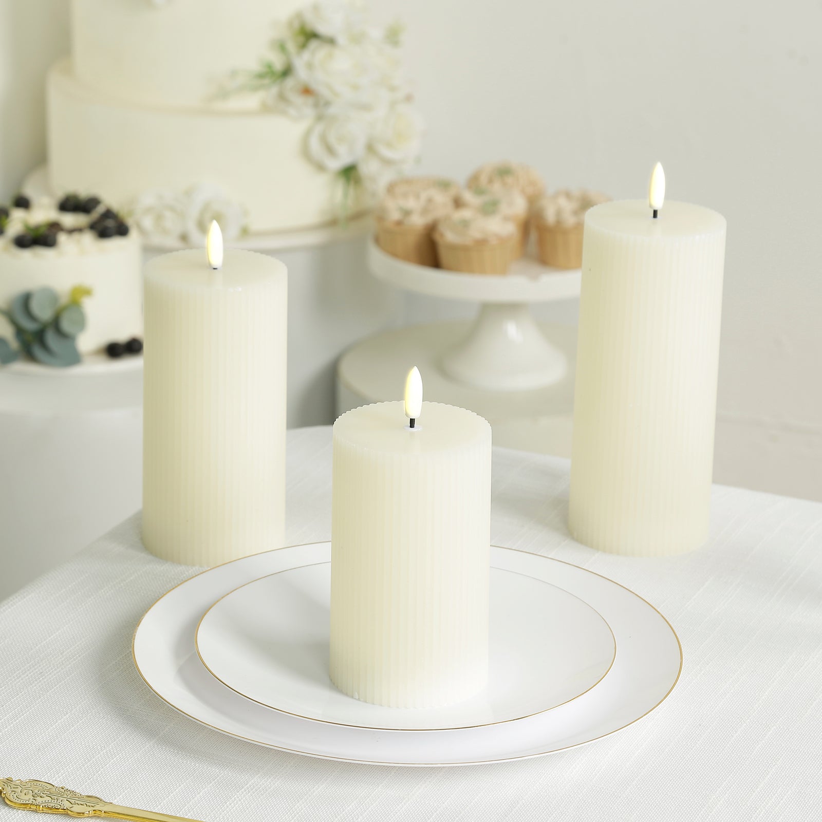 Ivory LED flameless pillar candles with ribbed design on a table.
