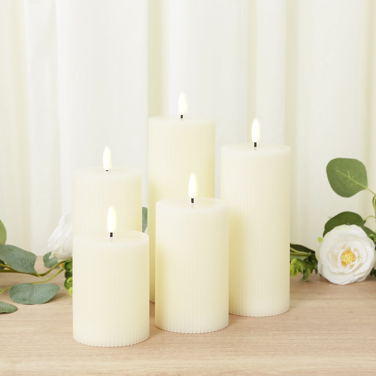 Ivory LED flameless pillar candles in ribbed design, warm white flickering glow.