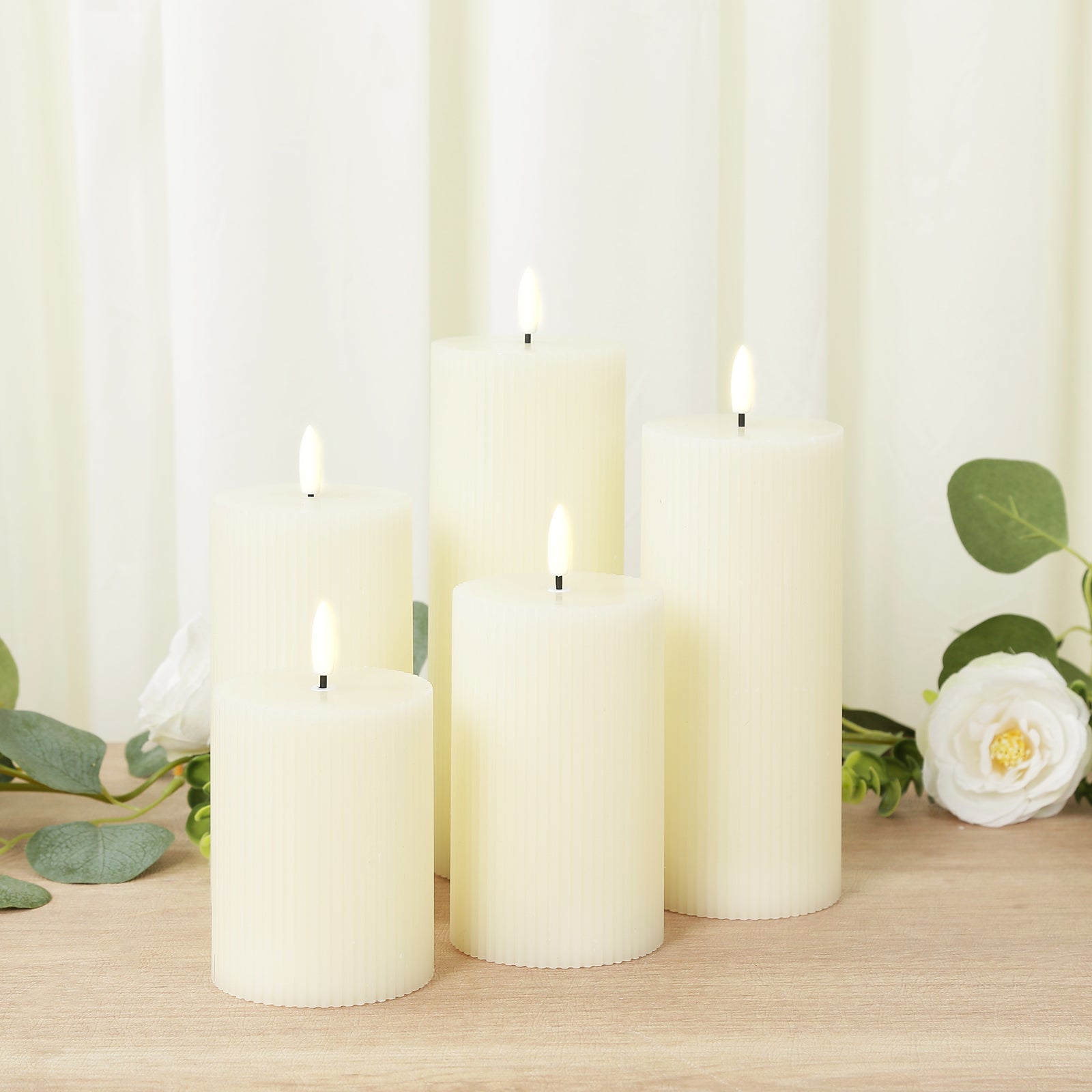 Ivory LED flameless pillar candles in ribbed design, warm white flickering glow.