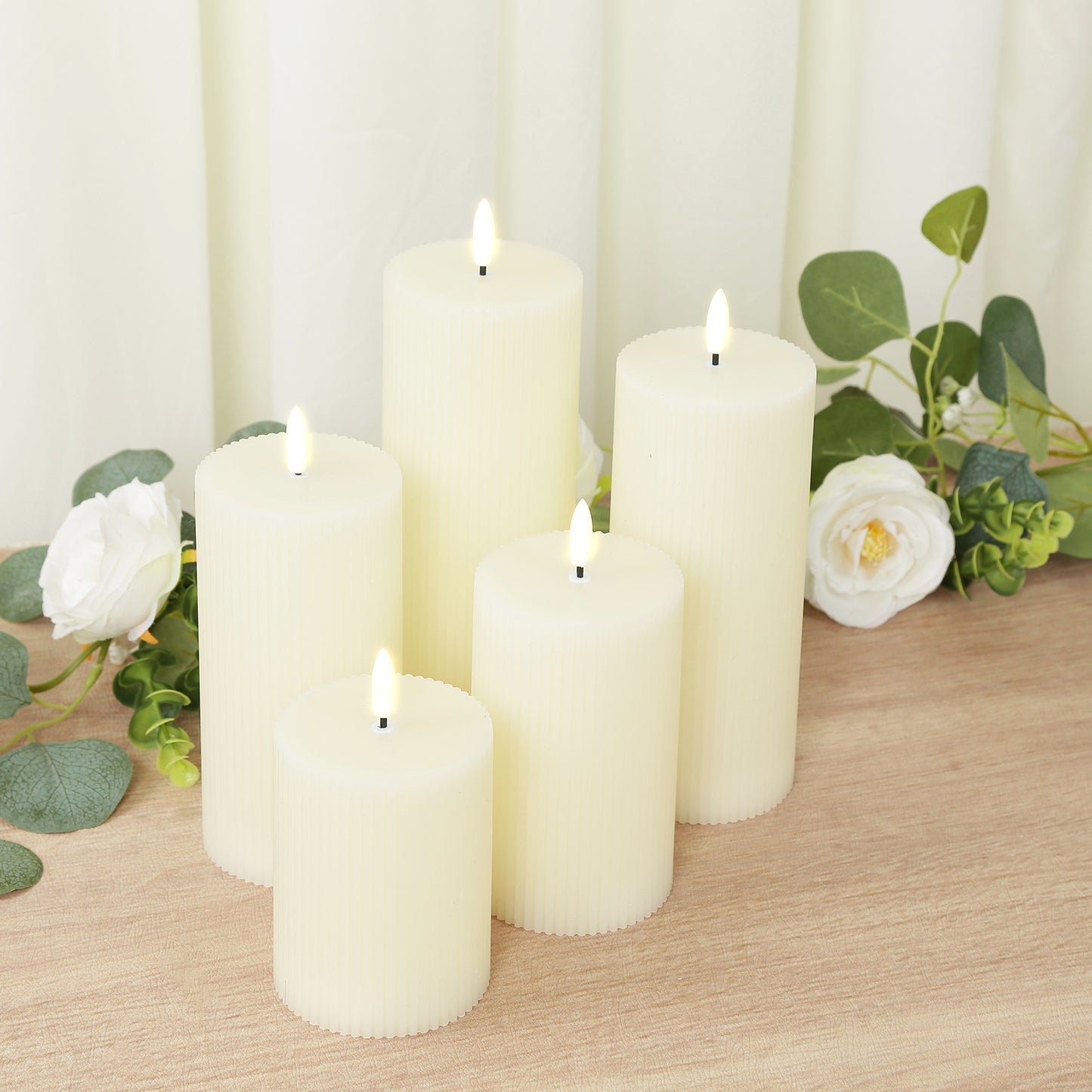 Ivory LED flameless pillar candles set with ribbed design and flickering flames.