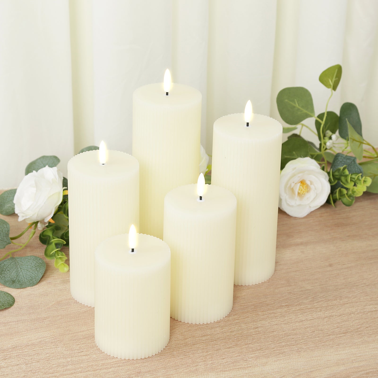 Ivory LED flameless pillar candles set with ribbed design and flickering flames.