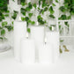 White LED flameless pillar candles in a ribbed design, flickering on a table.