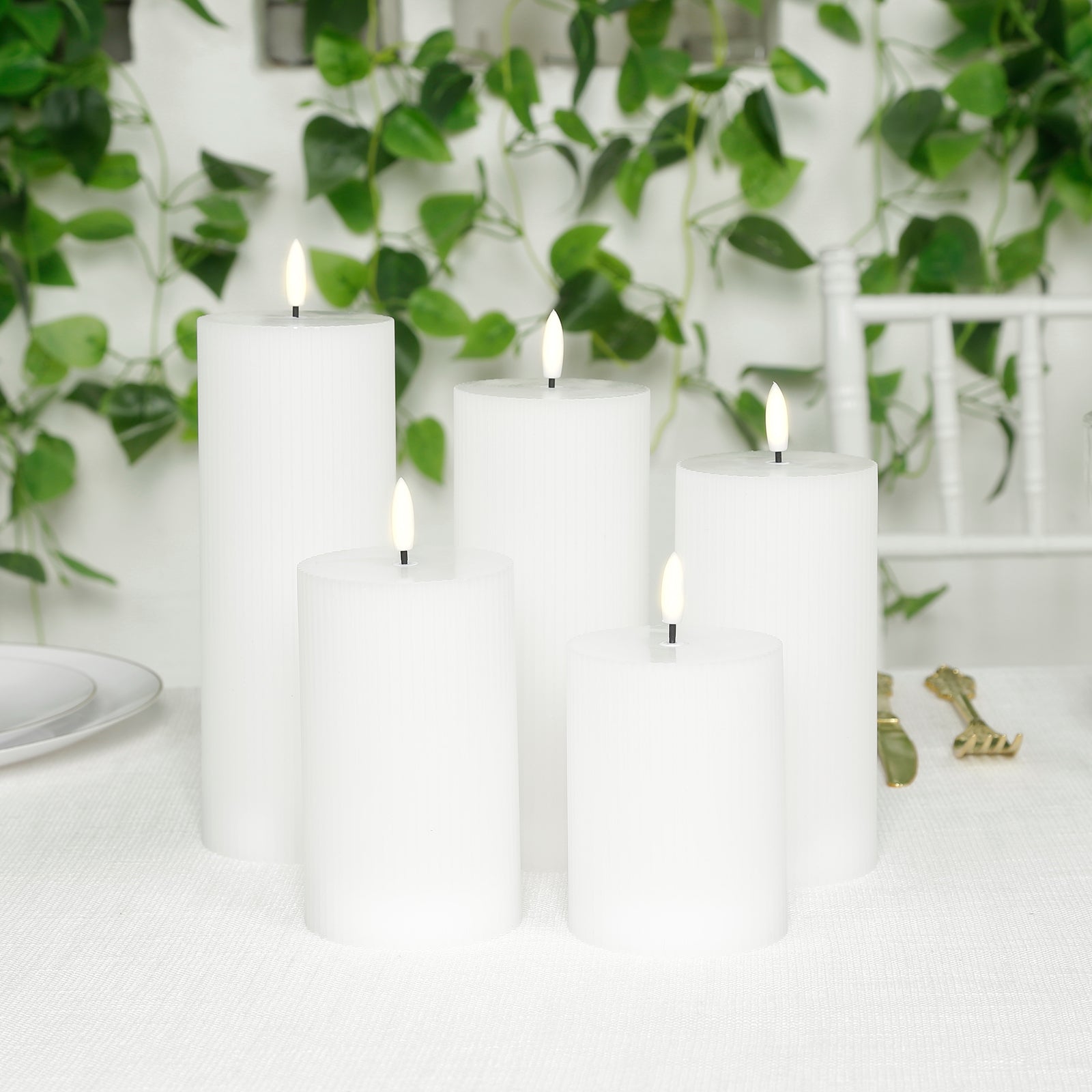 White LED flameless pillar candles in a ribbed design, flickering on a table.