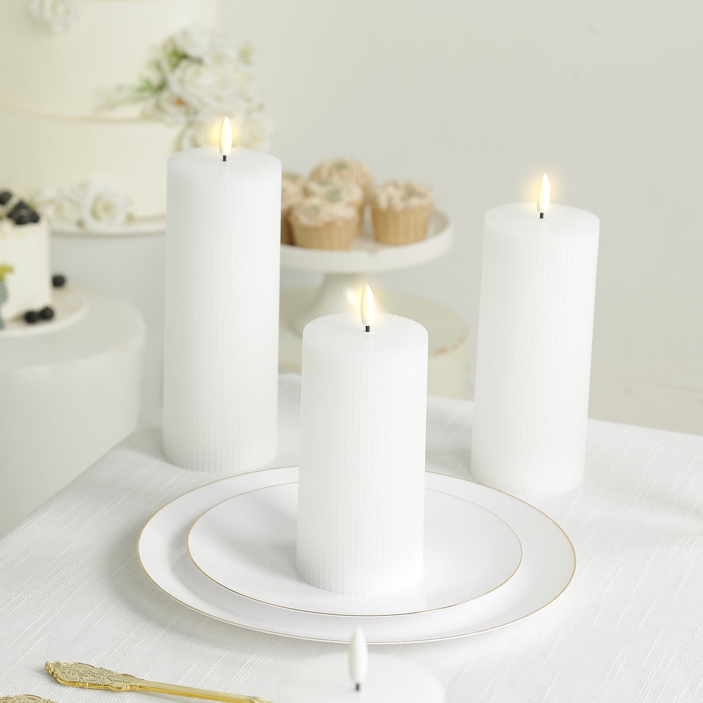 White LED flameless pillar candles with ribbed design on a table.