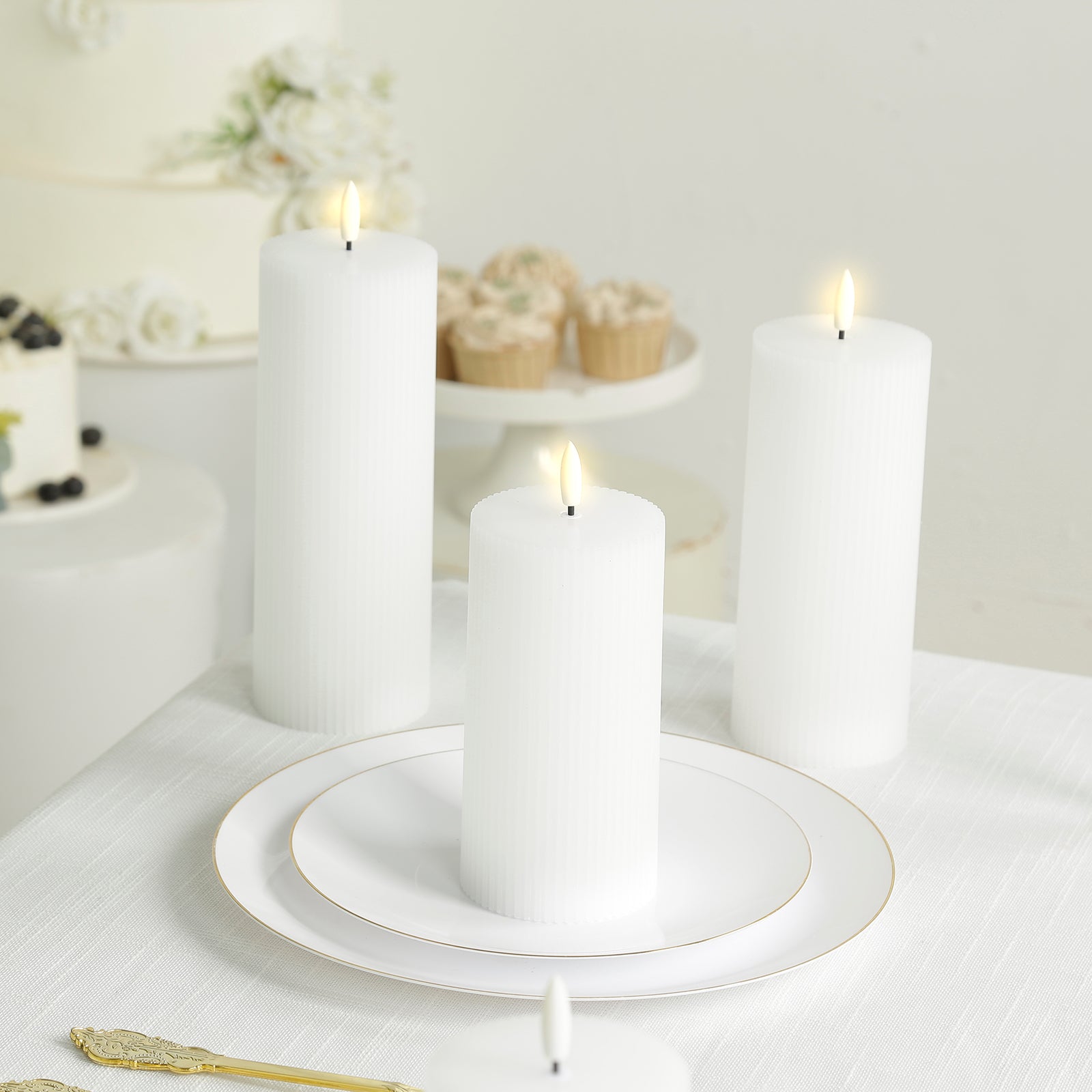 White LED flameless pillar candles with ribbed design on a table.