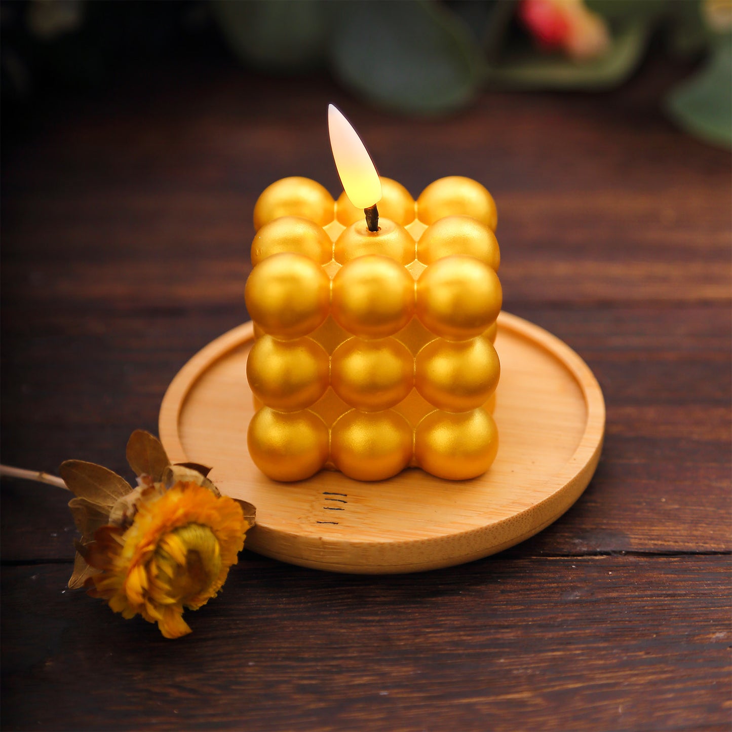 Metallic gold LED mini bubble candle on a wooden tray.