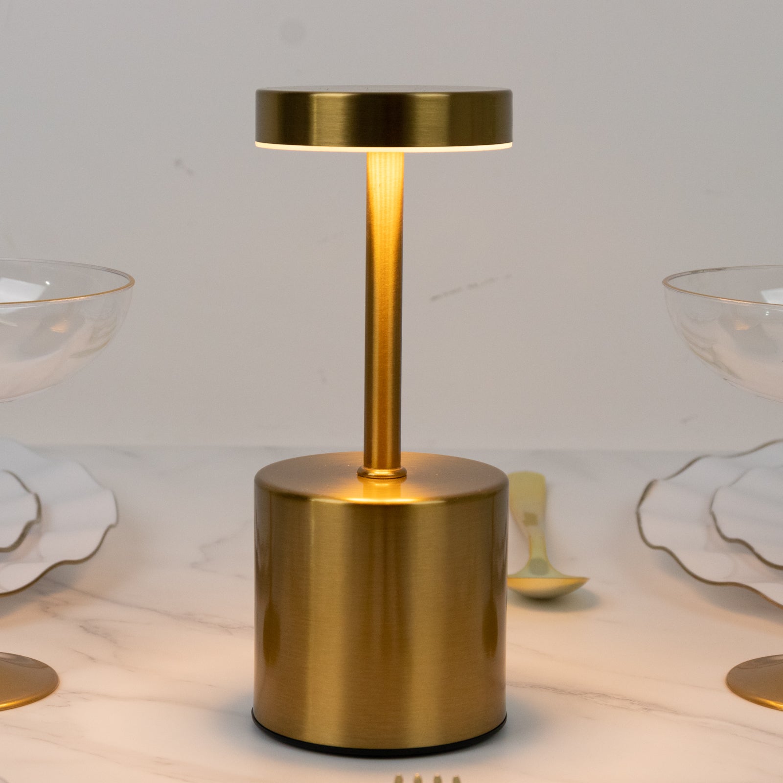 Gold metal LED table lamp with a modern minimalist design.