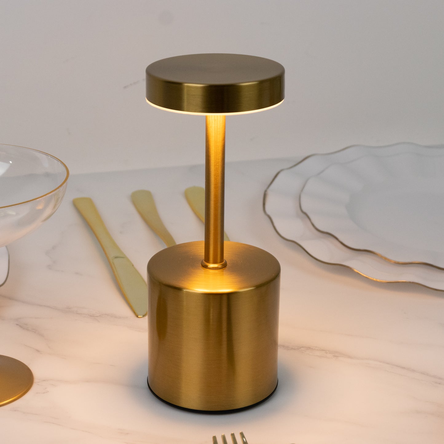 Gold metal LED table lamp with a modern minimalist design.